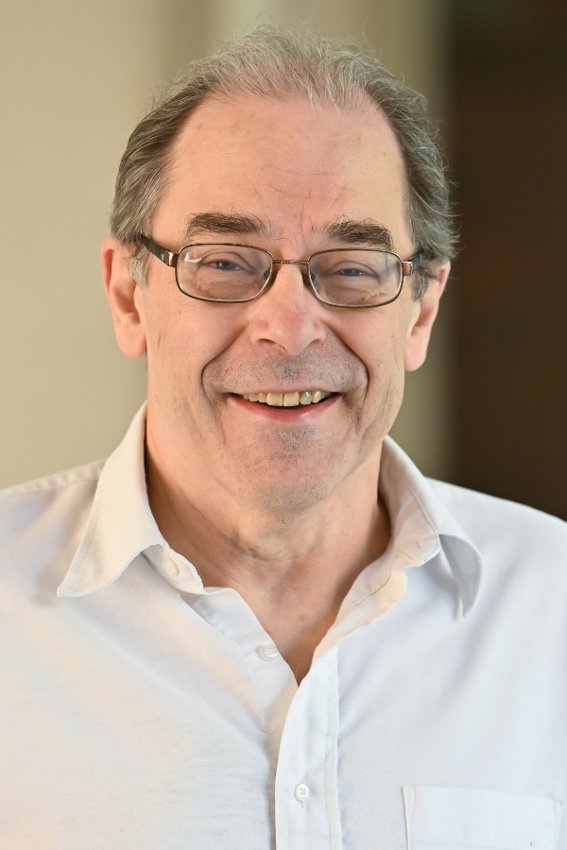 man with glasses and a white shirt smiling
