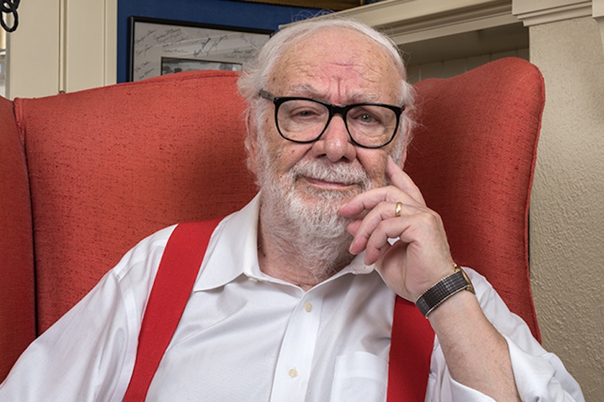 man with glasses sitting in a red chair