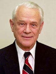 Man with white hair in a suit