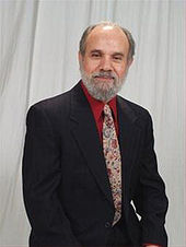 man in a black suit and red shirt